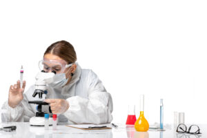 front view female doctor protective suit with mask using microscope white background covid virus pandemic health coronavirus